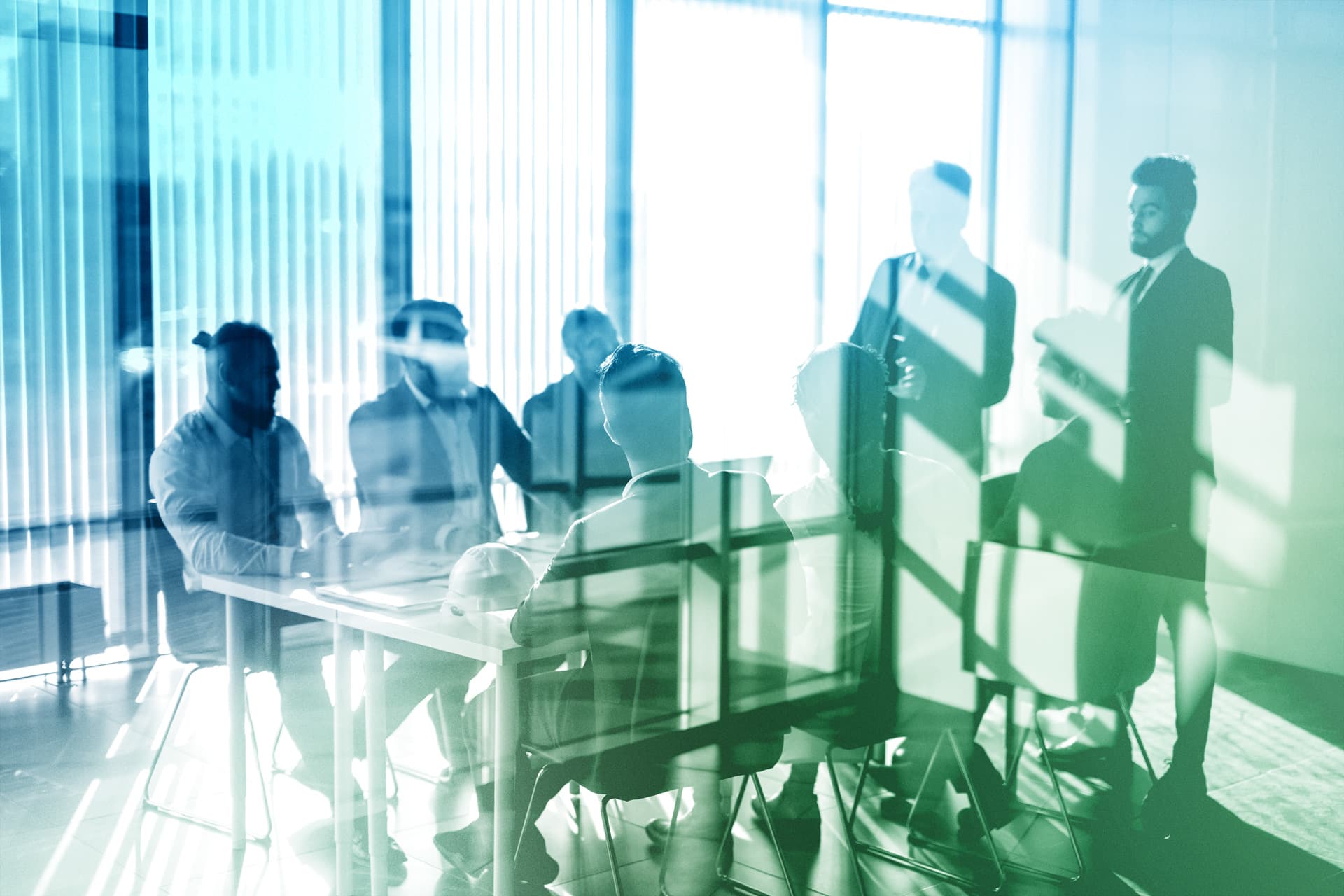 Meeting von Geschäftsleuten in modernem Büro; Fokus auf nachhaltige Immobilienprojekte und ESG-Investments durch SICORE.